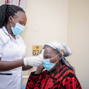 Beatrice's cataract surgery restored her vision. Pictured, she receives a post-surgery checkup. 